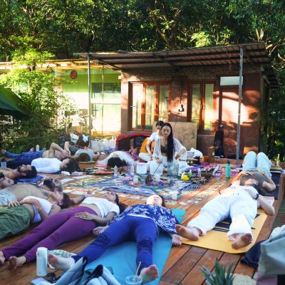 A woman meditating with closed eyes and folded hands behind a glowing lotus flower, promoting a spiritual ceremony in Sheung Wan.